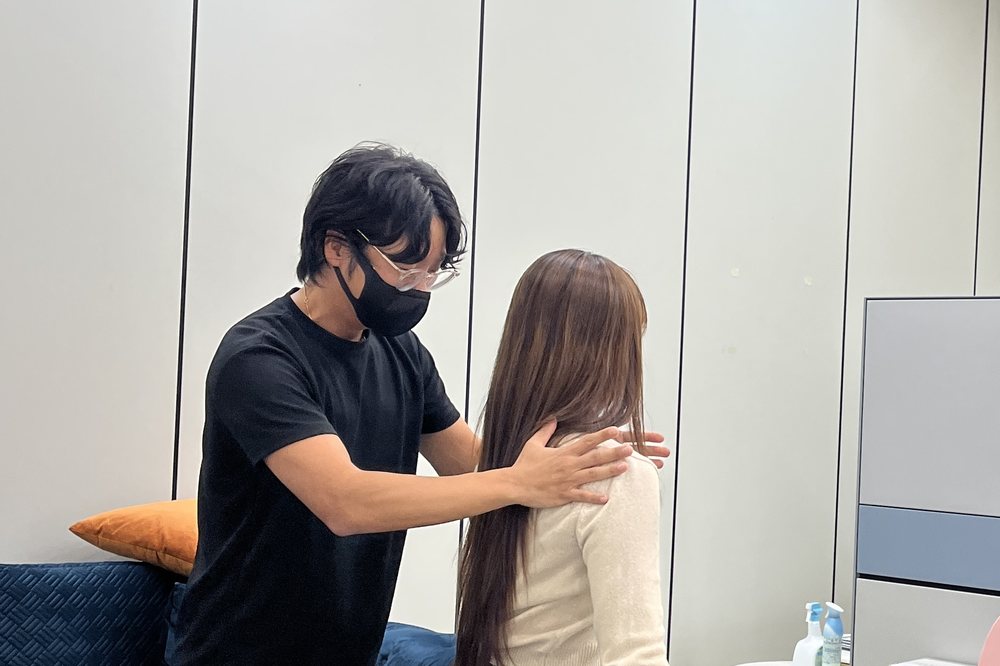 전문가가 고객의 어깨 상태를 확인하는 모습