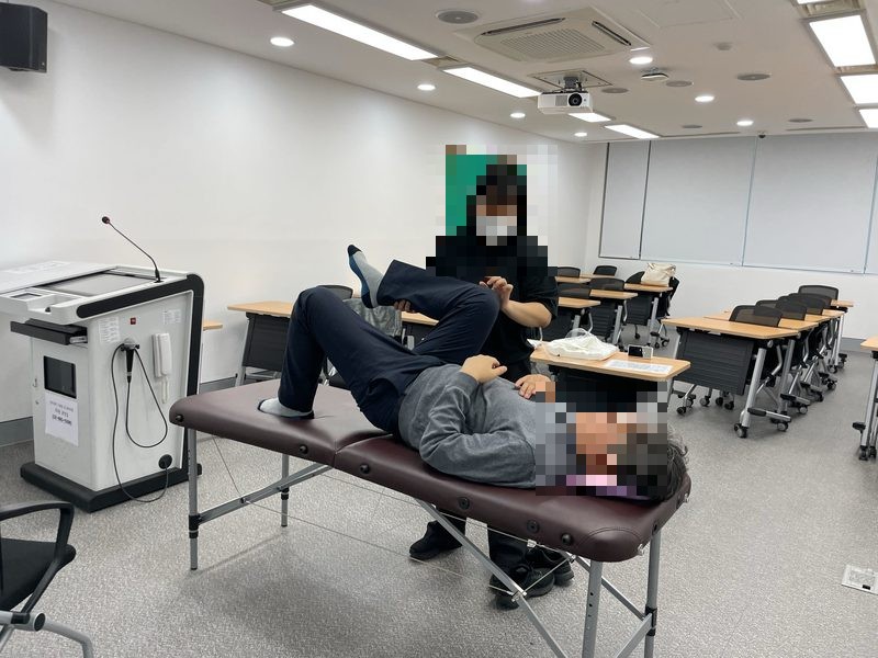 전문가가 고객의 다리와 골반 움직임을 확인하는 모습