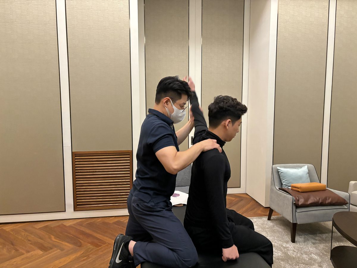 전문가가 고객의 어깨 움직임을 확인하는 모습